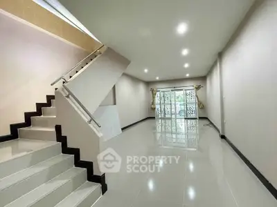 Spacious modern living room with sleek staircase and large windows