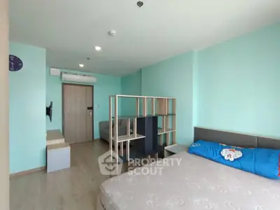 Modern studio apartment with partitioned living area and cozy bed setup