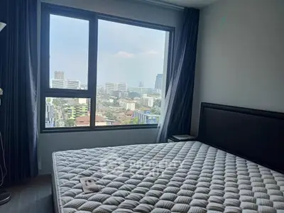 Spacious bedroom with large window offering stunning city views in modern apartment.