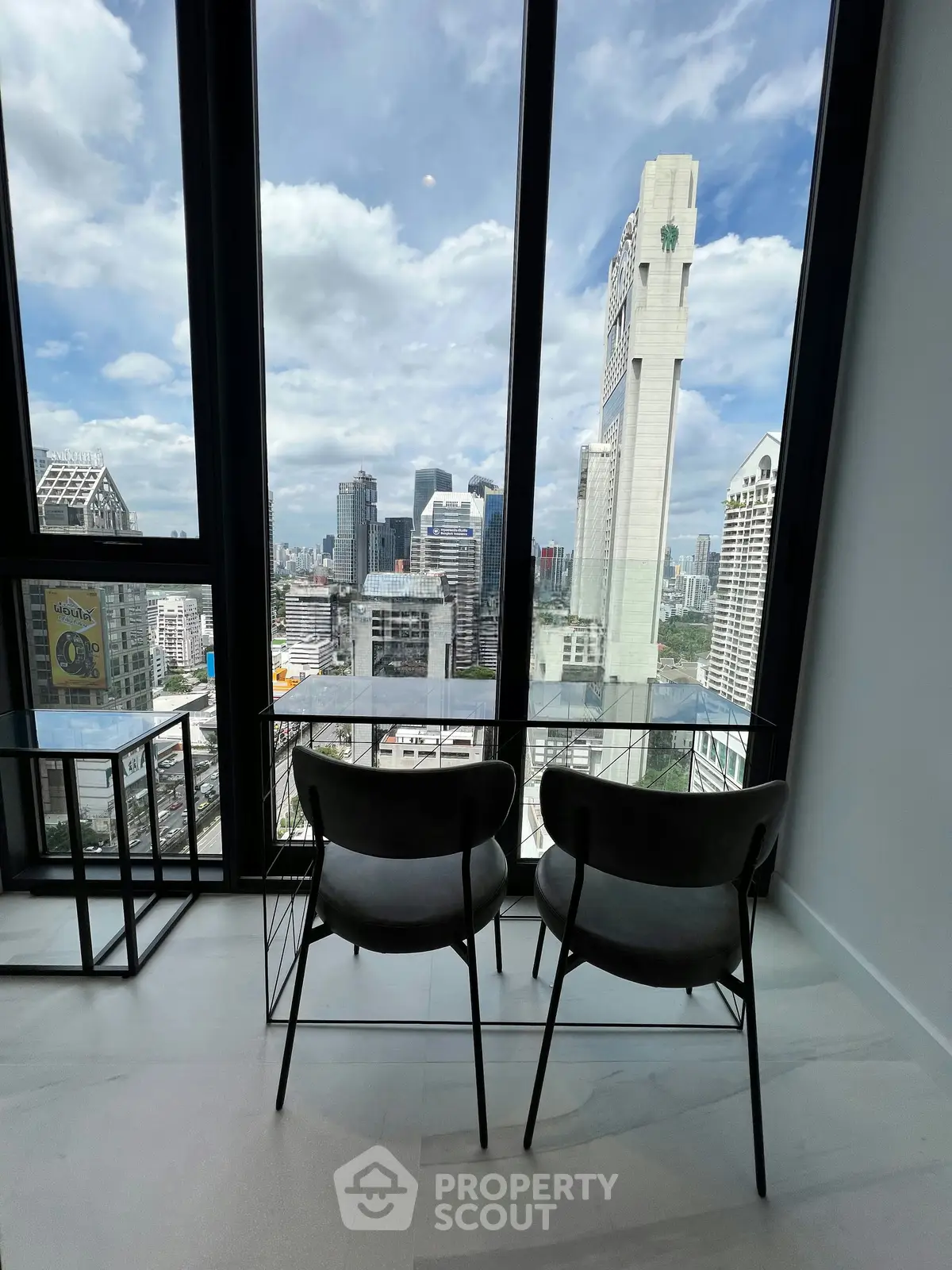 Stunning city view from modern high-rise apartment with floor-to-ceiling windows and sleek interior design.