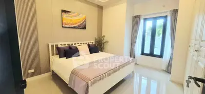 Modern bedroom with stylish decor and large window offering natural light