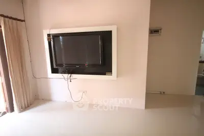 Spacious living room with mounted TV and natural light