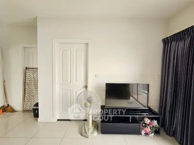 Modern living room with sleek TV stand and elegant curtains, perfect for cozy relaxation.