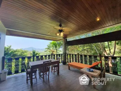 Spacious outdoor balcony with stunning mountain views and cozy seating area.