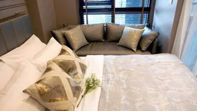 Luxurious bedroom with elegant bedding and stylish sofa, perfect for relaxation and comfort.