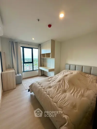 Modern bedroom with large window and stylish decor in a high-rise apartment.
