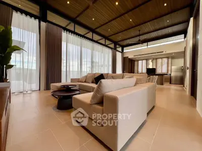 Luxurious open-plan living room with modern decor and expansive windows