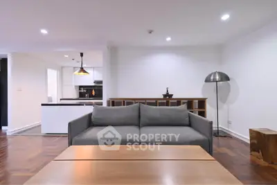 Modern living room with sleek furniture and open kitchen layout, perfect for contemporary living.