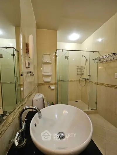 Modern bathroom with glass shower and stylish sink in elegant home.