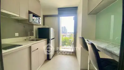 Modern kitchen with balcony view, featuring sleek appliances and breakfast bar seating.