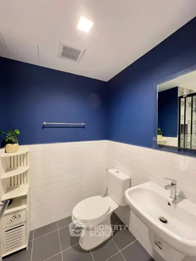 Modern bathroom with blue accent wall and sleek fixtures