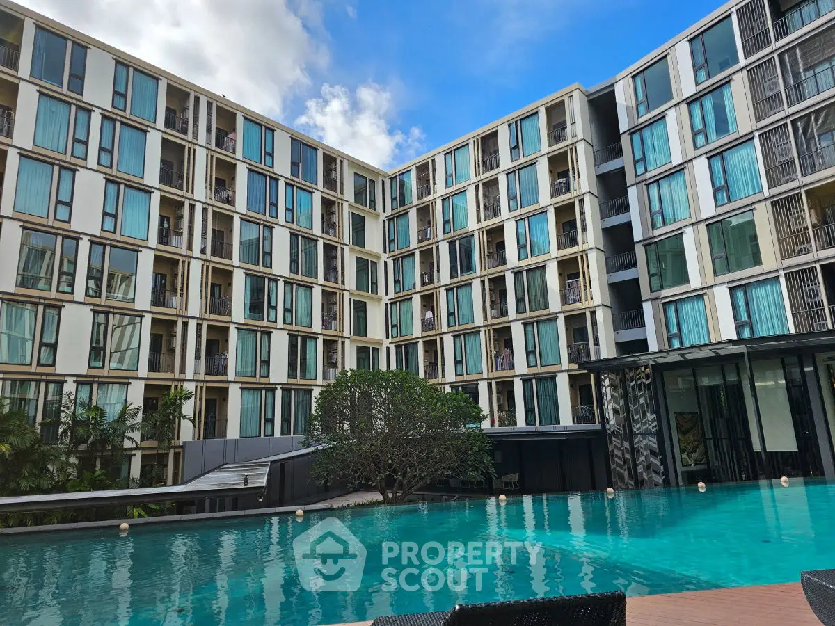 Modern apartment complex with a stunning pool and lush greenery, perfect for urban living.