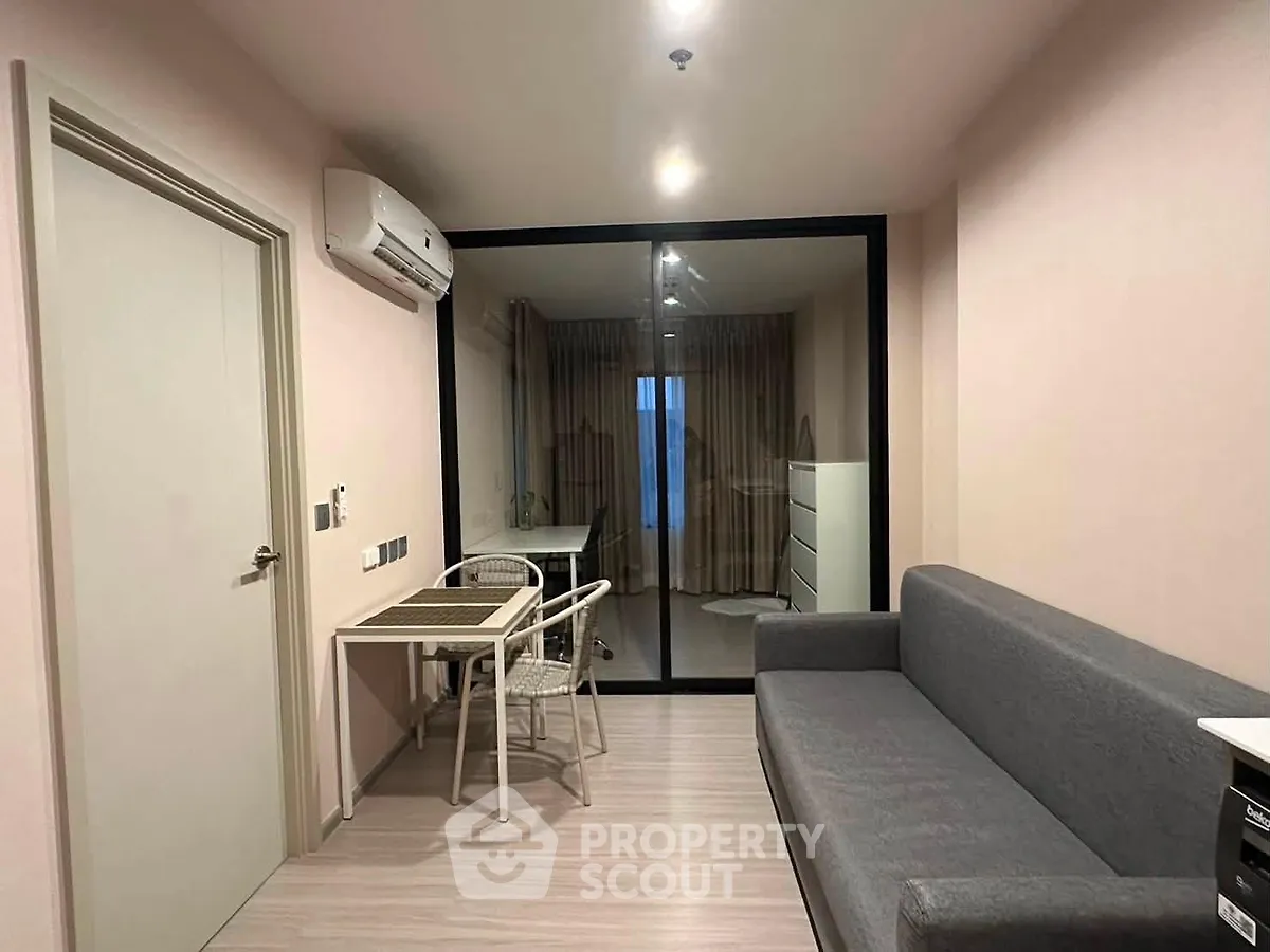 Modern living room with sleek furniture and glass partition in a stylish apartment.
