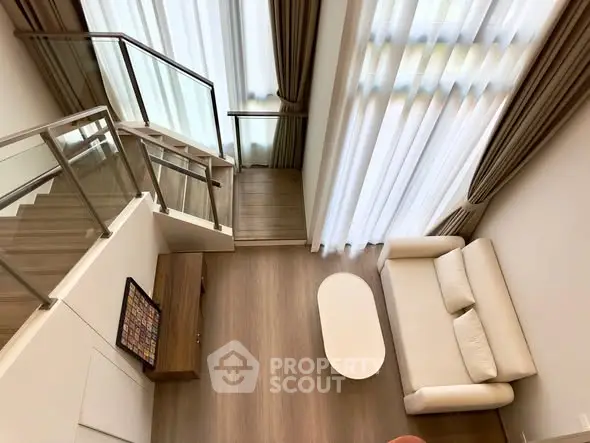 Modern duplex living room with high ceilings and elegant staircase