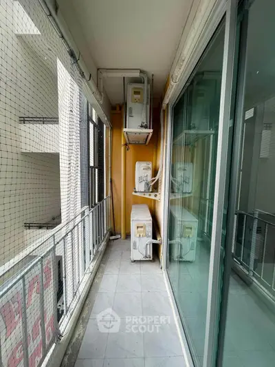 Spacious balcony with air conditioning units in modern apartment building.