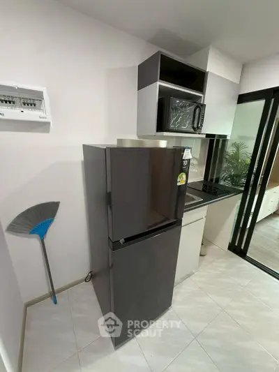 Modern kitchen with sleek appliances and stylish cabinetry in a contemporary apartment.