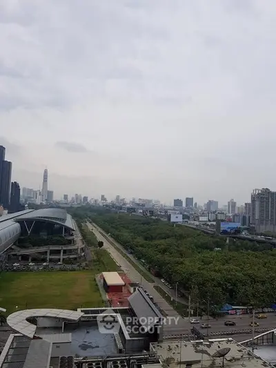 Stunning cityscape view from a high-rise building showcasing urban skyline and lush greenery.