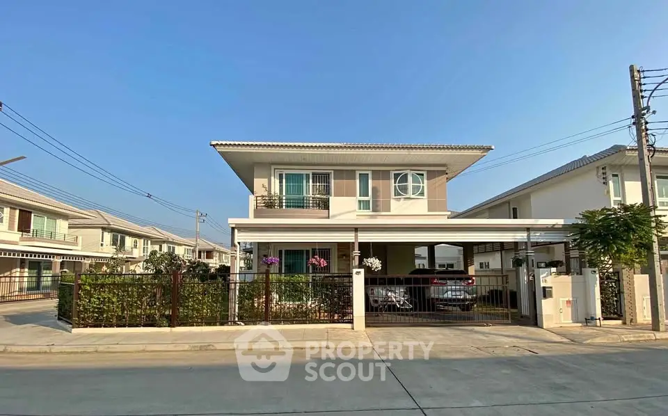 Modern two-story house with a spacious driveway and well-maintained garden in a suburban neighborhood.