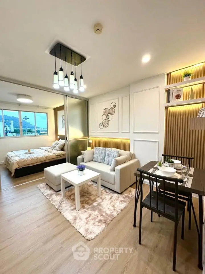 Modern open-plan living room with cozy dining area and stylish bedroom in a chic apartment.