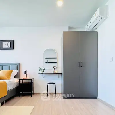 Modern bedroom with stylish decor, featuring a sleek wardrobe and air conditioning.