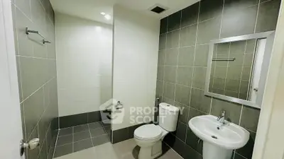 Modern bathroom with sleek tiles and contemporary fixtures in a stylish real estate property.
