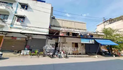 Street view of mixed-use building with shops and residential units
