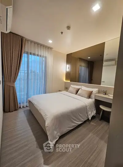 Modern bedroom with elegant decor and large window offering city views