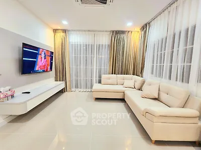 Spacious modern living room with elegant beige sofas and wall-mounted TV