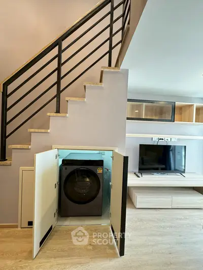 Modern duplex with built-in washing machine under staircase and sleek entertainment unit.