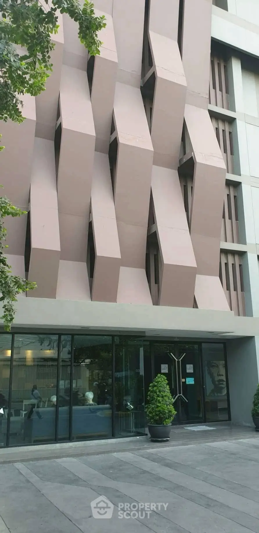 Modern architectural building facade with unique geometric design and glass entrance.
