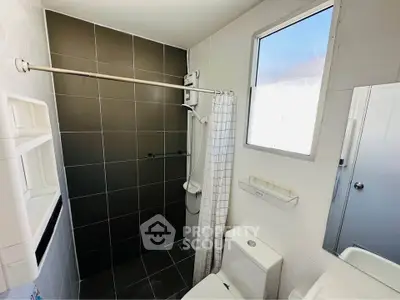 Modern bathroom with sleek black tiles and natural light