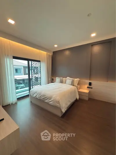 Modern bedroom with large window and elegant wooden flooring