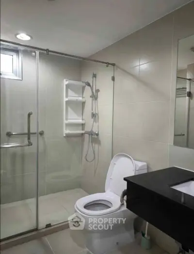 Modern bathroom with glass shower and sleek fixtures in a contemporary home.