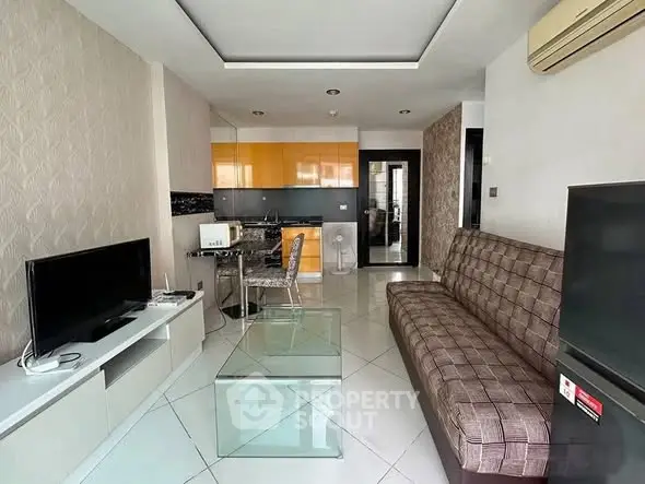 Modern living room with sleek furniture and open kitchen layout in stylish apartment.