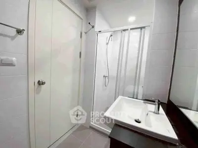 Modern bathroom with sleek shower and stylish sink in a contemporary home.