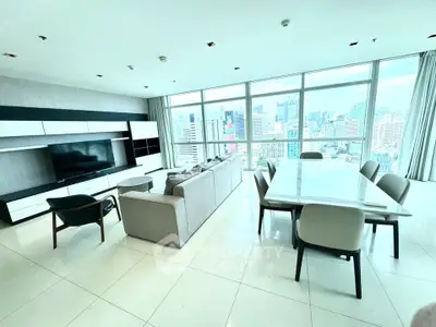 Spacious modern living room with city view, elegant furniture, and large windows.