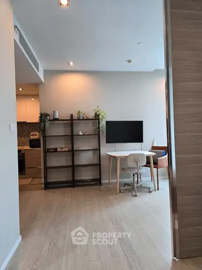 Modern living space with open layout and stylish decor, featuring a cozy study area and sleek kitchen.