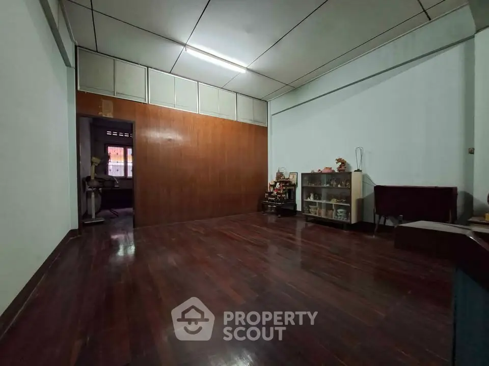 Spacious empty room with wooden flooring and minimal decor, ideal for customization.