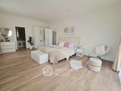 Spacious and elegantly designed bedroom with modern decor and wooden flooring.