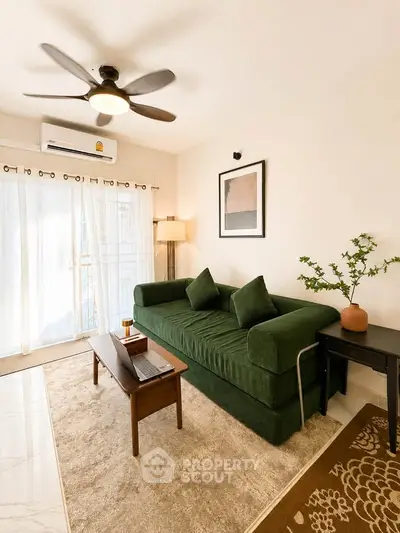 Stylish living room with green sofa, modern decor, and natural light