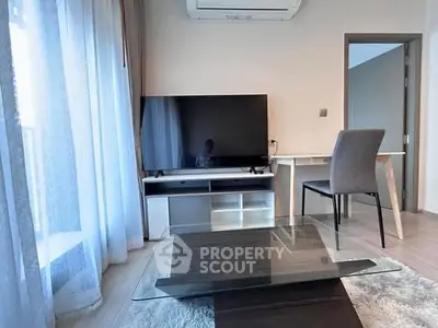 Modern living room with sleek furniture and large TV, perfect for relaxation.