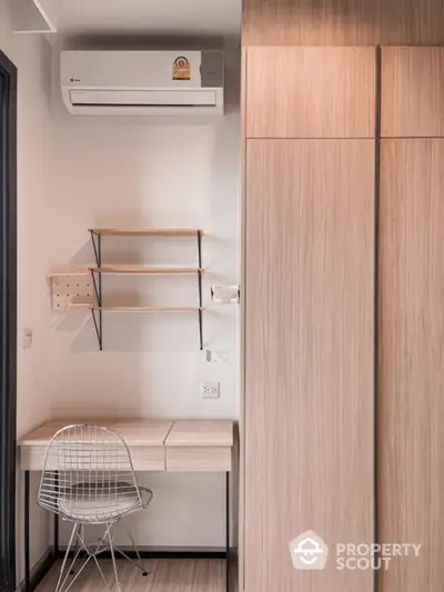 Modern study nook with wooden desk, shelves, and air conditioning in a cozy apartment.