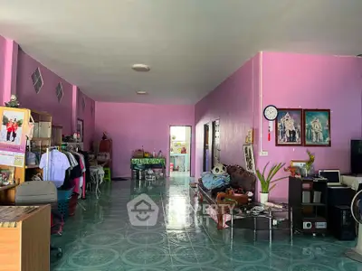 Spacious living room with vibrant pink walls and eclectic decor, perfect for creative living.