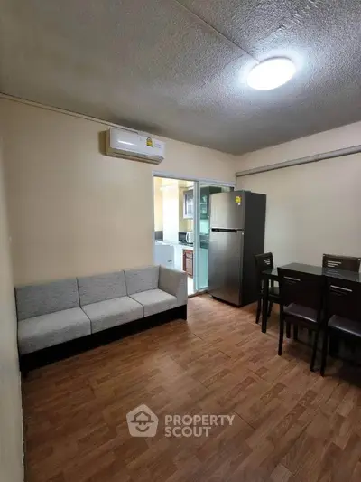 Cozy living room with modern furniture and kitchen view in a stylish apartment.