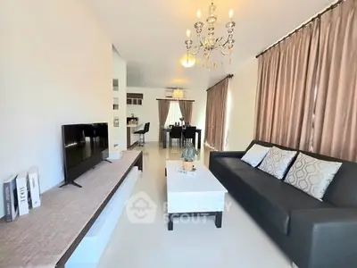 Spacious modern living room with elegant chandelier and sleek furniture design.