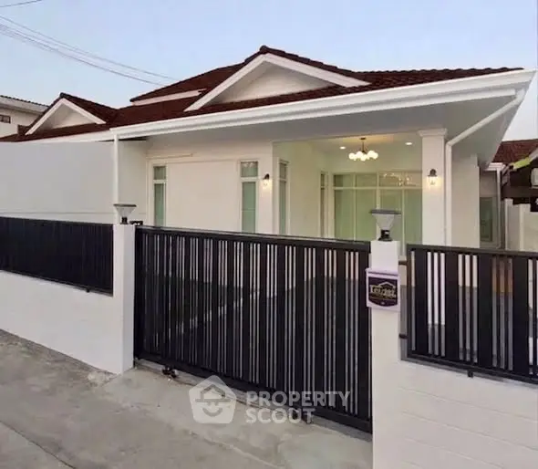 Charming single-story house with modern fence and elegant lighting, perfect for family living.