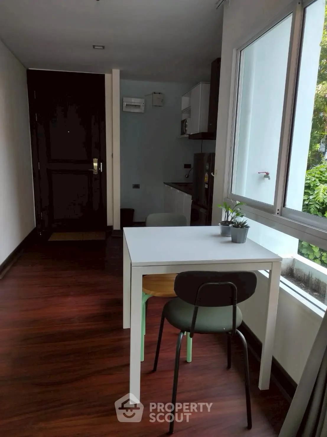 Cozy dining area with natural light and modern decor in a compact apartment.