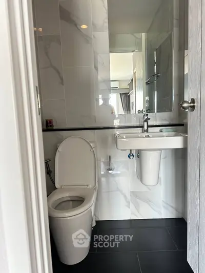 Modern bathroom with sleek fixtures and marble tiles, perfect for a contemporary home.