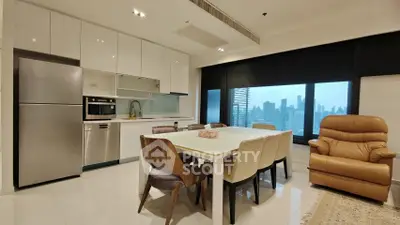 Modern kitchen and dining area with city view, featuring sleek appliances and comfortable seating.