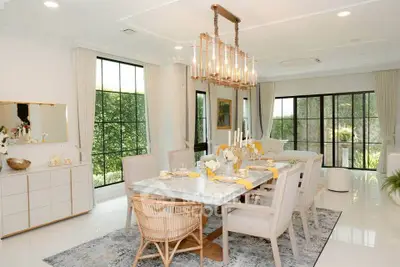 Luxurious dining room with elegant decor and large windows offering garden views.